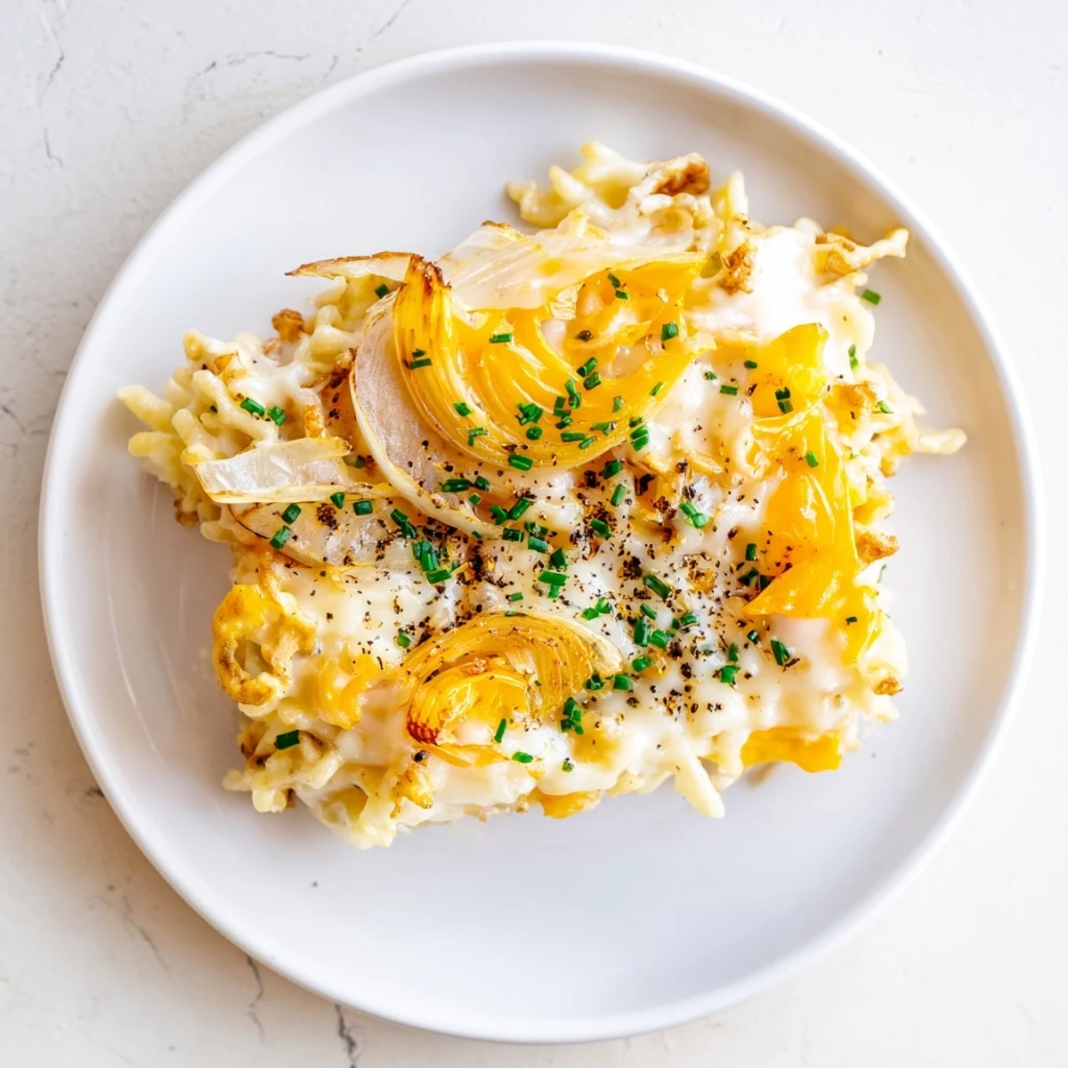 Wärmende Käse-Spaetzle, überbacken mit goldgelbem Käse und karamellisierten Zwiebeln.  